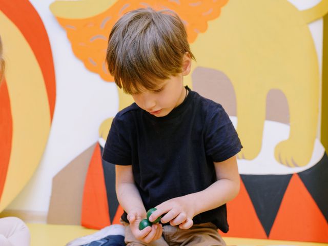A child making a craft against a colourful activity-room wall